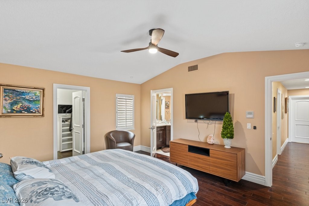 7 Larkside Court Henderson, NV 89014 - Photo 45 of 70 Bedroom featuring a walk in closet, dark wood-type flooring, ceiling fan, vaulted ceiling, and connected bathroom
