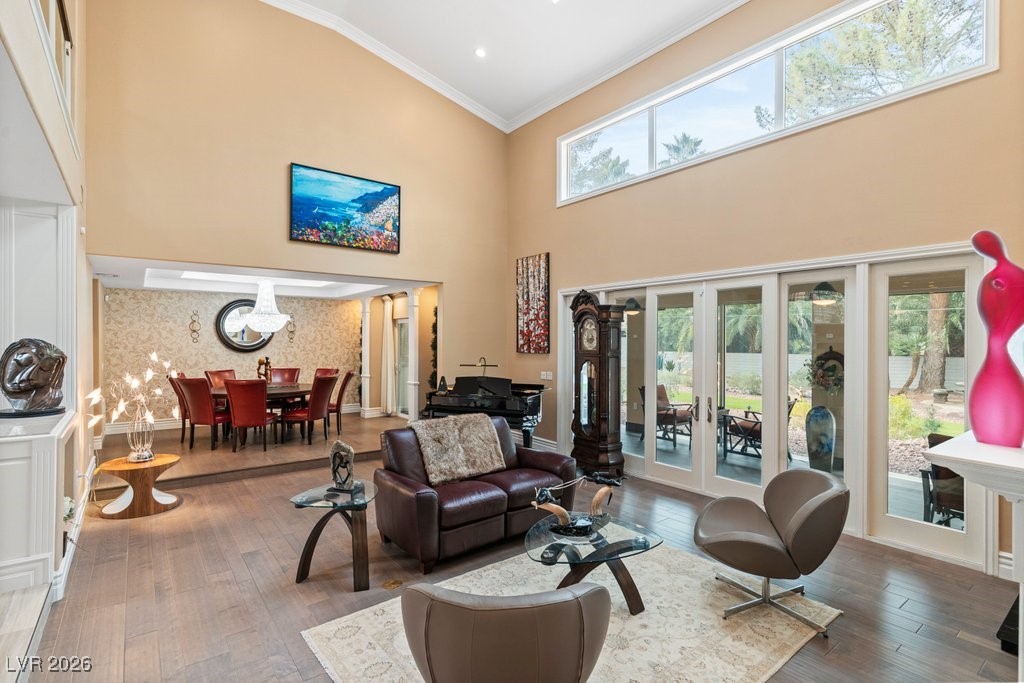 7 Larkside Court Henderson, NV 89014 - Photo 5 of 70 Living area featuring crown molding, hardwood / wood-style floors, french doors, wallpapered walls, and a towering ceiling