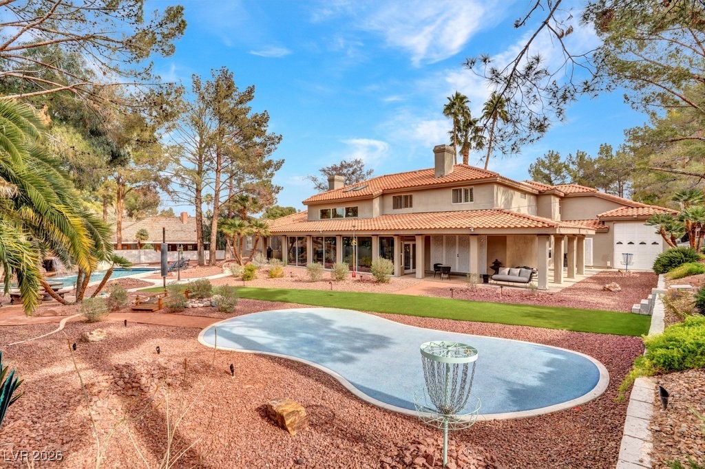 7 Larkside Court Henderson, NV 89014 - Photo 55 of 70 Back of house featuring a chimney, a patio area, stucco siding, a pool, and a tiled roof