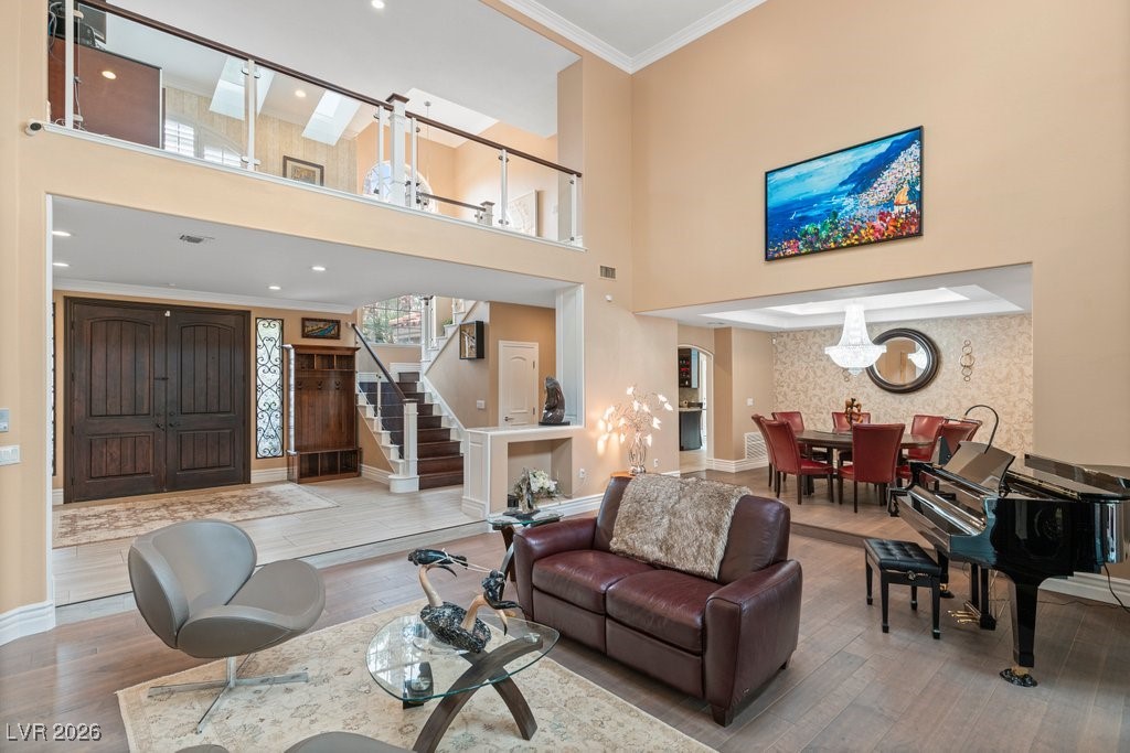 7 Larkside Court Henderson, NV 89014 - Photo 7 of 70 Living area featuring stairway, wood finished floors, a high ceiling, ornamental molding, and recessed lighting