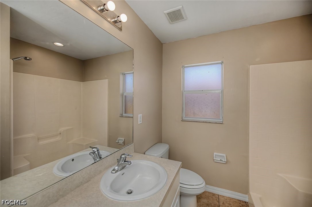 4104 13th Street Southwest Lehigh Acres, FL 33976 - Photo 29 of 46 a bathroom with a bathtub shower sink mirror and toilet