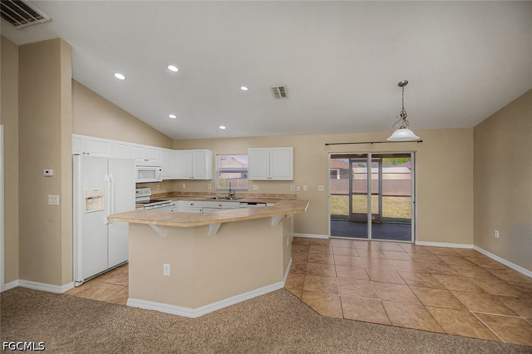 4104 13th Street Southwest Lehigh Acres, FL 33976 - Photo 7 of 46 a kitchen with kitchen island a sink a stove a refrigerator and a dining table