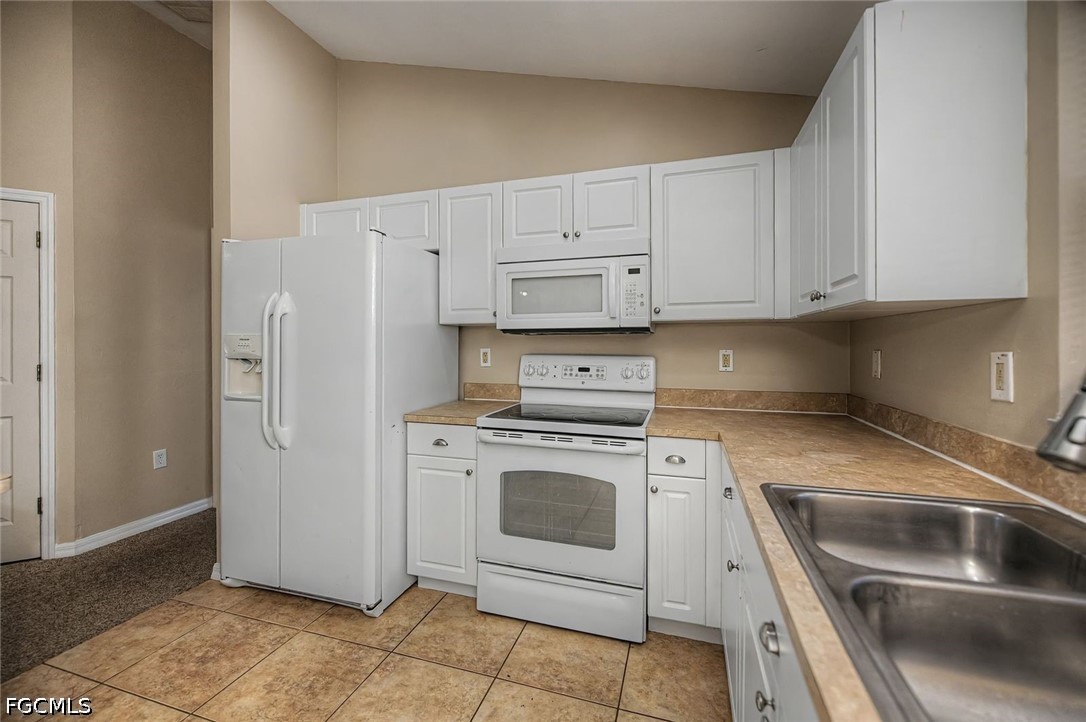 4104 13th Street Southwest Lehigh Acres, FL 33976 - Photo 9 of 46 a kitchen with cabinets and white stainless steel appliances