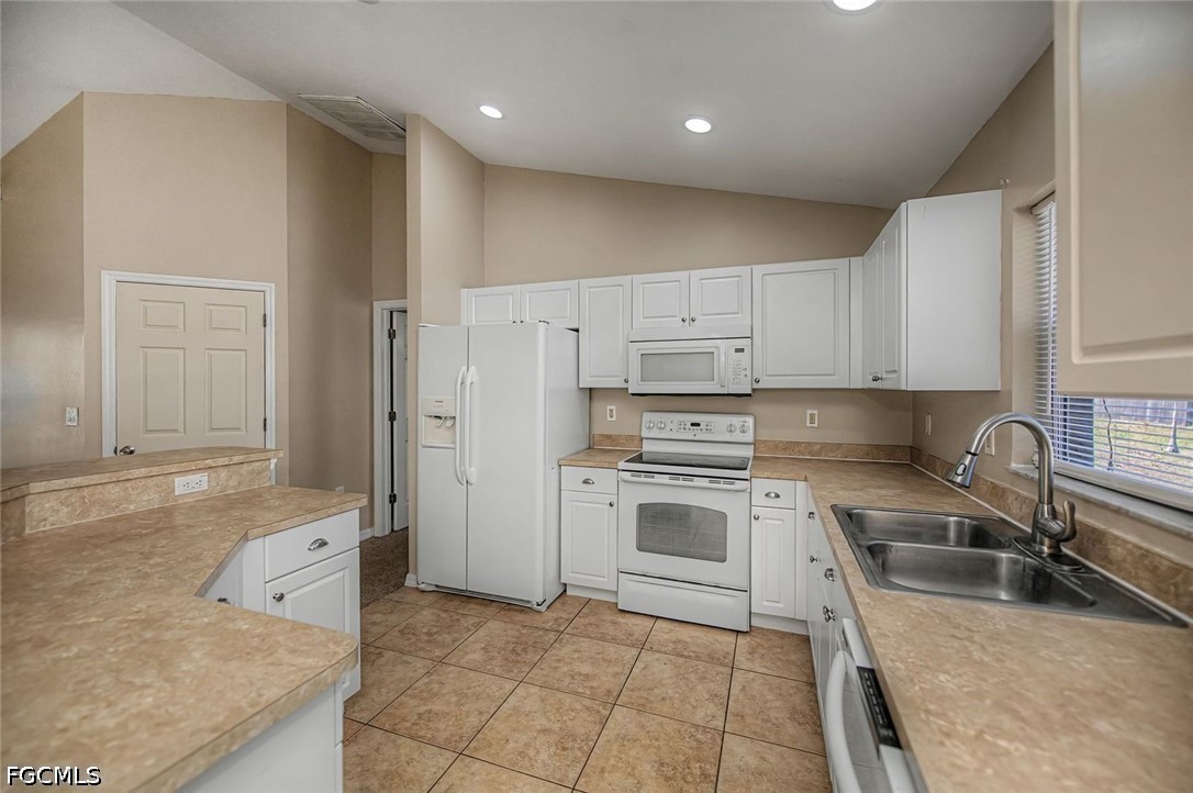 4104 13th Street Southwest Lehigh Acres, FL 33976 - Photo 10 of 46 a kitchen with a stove a sink and a refrigerator