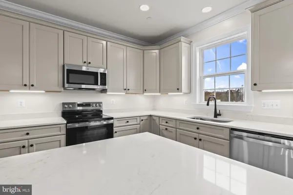 a kitchen with kitchen island granite countertop a stove sink and microwave