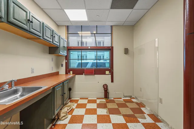 a room with a black white checkered floor and a dining table
