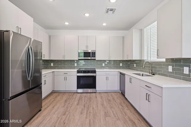 a kitchen with stainless steel appliances a refrigerator sink and microwave
