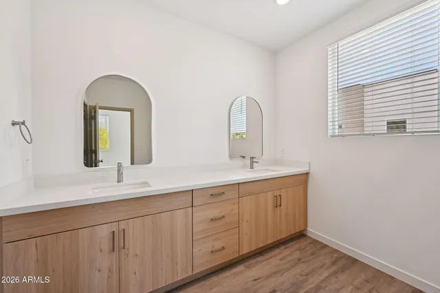 a bathroom with a double vanity sink and a window