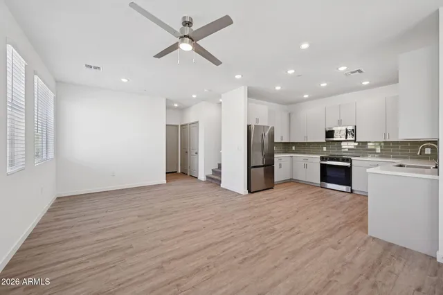 a view of kitchen with refrigerator stove and wooden floor