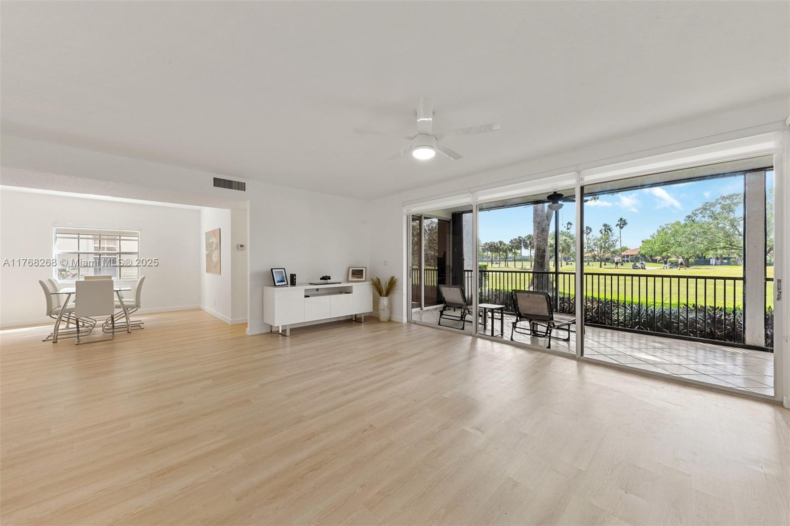 7658 Elm Ridge Drive, Unit 17U Boca Raton, FL 33433 - Photo 12 of 39 LIVING ROOM, DINING ROOM AND PATIO VIEW OF GOLF COURSE
