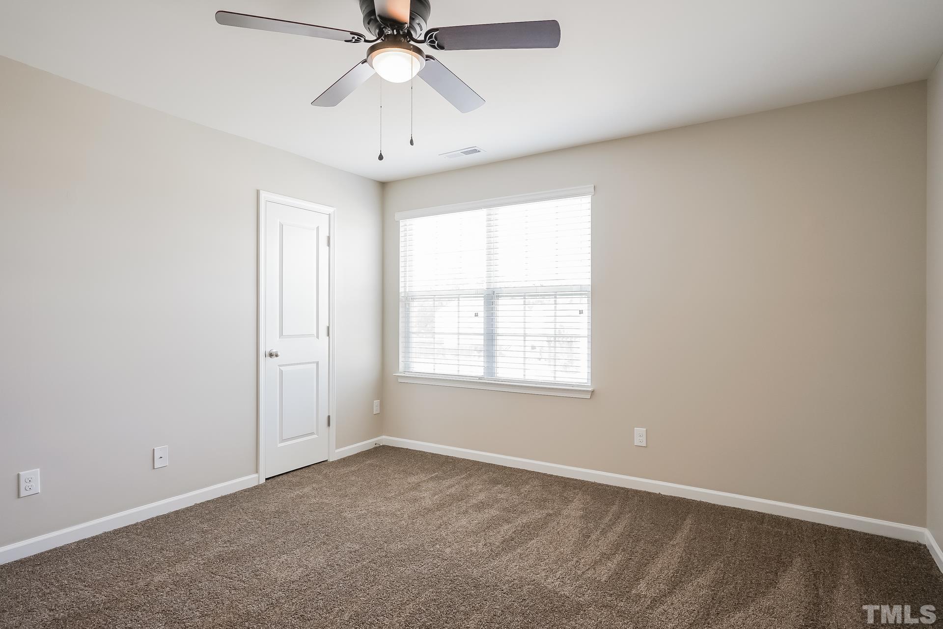 901 Rose Mallow Drive Zebulon, NC 27597 - Photo 11 of 15 an empty room with a window and a fan