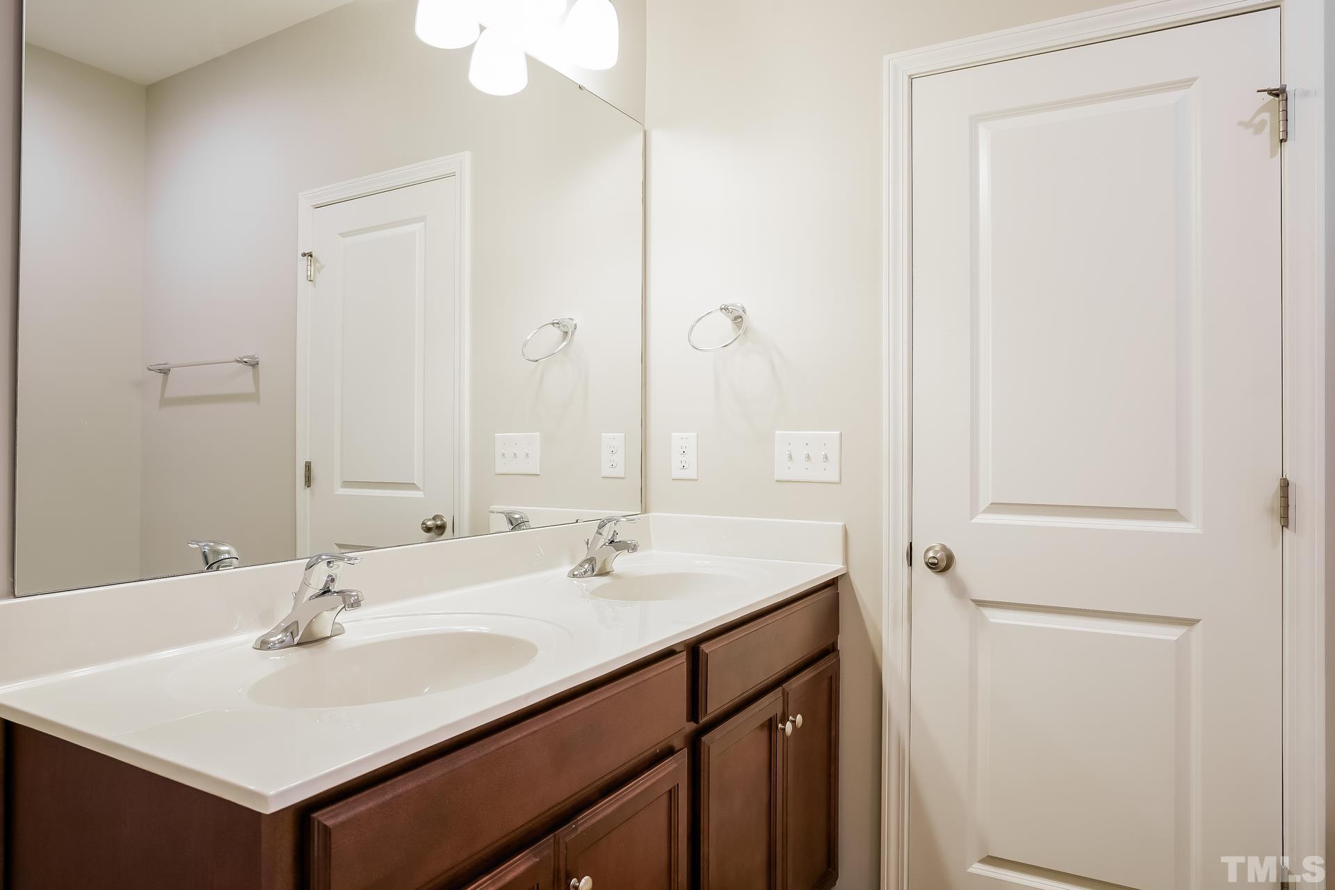 901 Rose Mallow Drive Zebulon, NC 27597 - Photo 14 of 15 a bathroom with a sink and a mirror