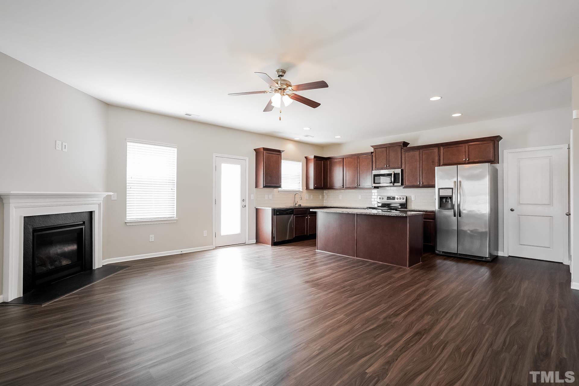 901 Rose Mallow Drive Zebulon, NC 27597 - Photo 2 of 15 a large kitchen with cabinets wooden floor and a fireplace