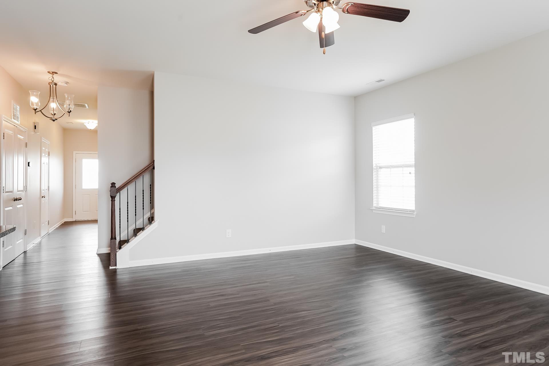 901 Rose Mallow Drive Zebulon, NC 27597 - Photo 3 of 15 an empty room with wooden floor chandelier and windows