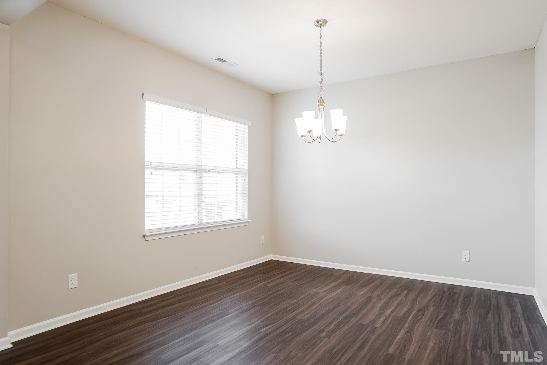 901 Rose Mallow Drive Zebulon, NC 27597 - Photo 4 of 15 an empty room with wooden floor and windows