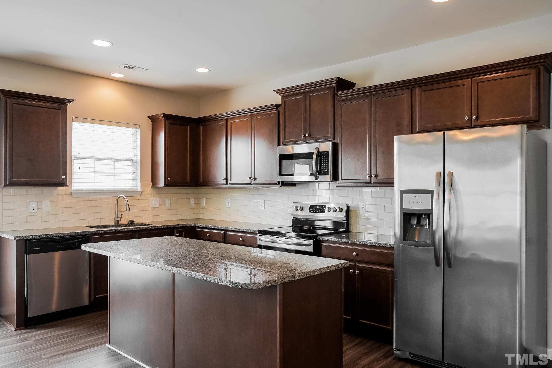 901 Rose Mallow Drive Zebulon, NC 27597 - Photo 5 of 15 a kitchen with a refrigerator sink and microwave