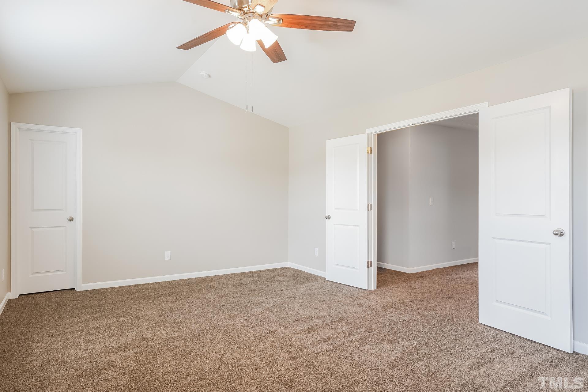 901 Rose Mallow Drive Zebulon, NC 27597 - Photo 9 of 15 an empty room with closet and a chandelier fan