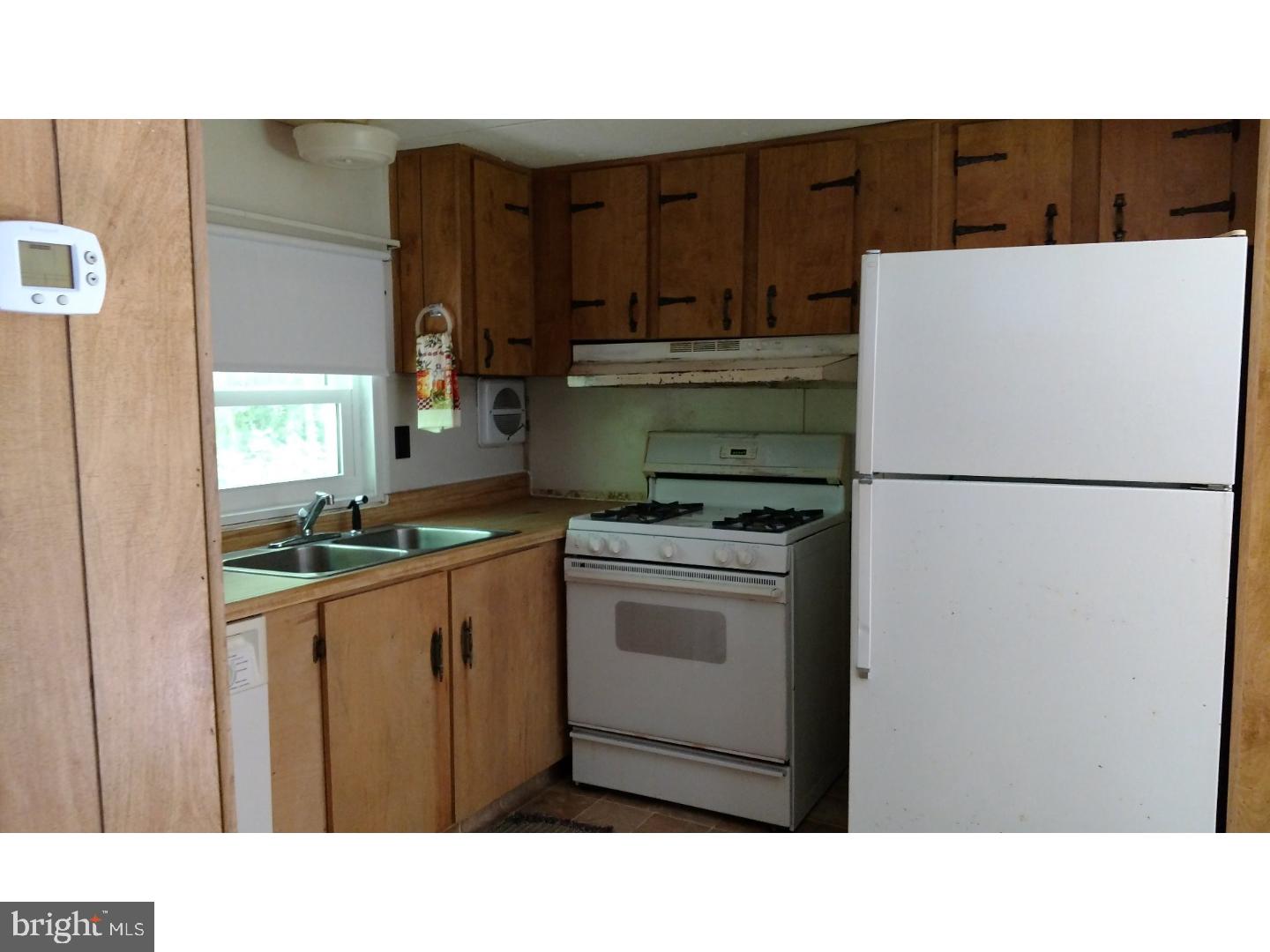 14122 Oak Branch Road Delmar, DE 19940 - Photo 14 of 25 a kitchen with a refrigerator and a stove