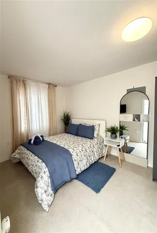 a bedroom with bed couch and window