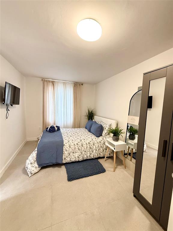 2420 Southwest 11th Street, Unit B Miami, FL 33135 - Photo 3 of 12 a bedroom with double bed and a couch