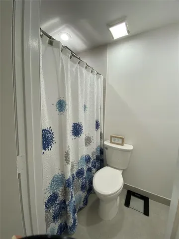 a white toilet sitting next to a shower curtain