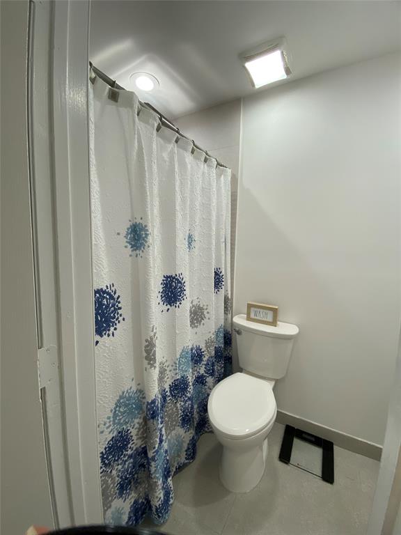 2420 Southwest 11th Street, Unit B Miami, FL 33135 - Photo 5 of 12 a white toilet sitting next to a shower curtain