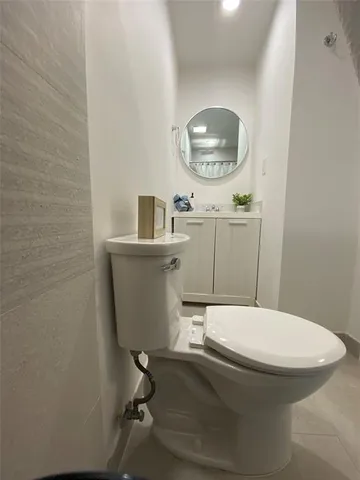 a bathroom with a toilet a sink and mirror