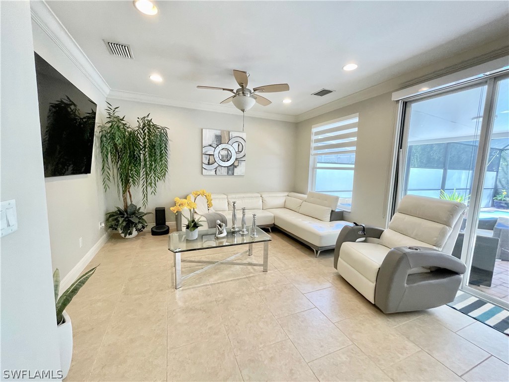 10816 Marble Brook Boulevard Lehigh Acres, FL 33936 - Photo 12 of 41 a living room with furniture and a flat screen tv