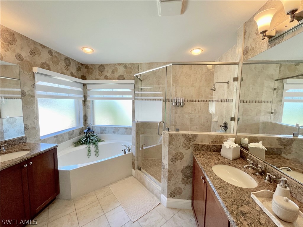 10816 Marble Brook Boulevard Lehigh Acres, FL 33936 - Photo 19 of 41 a bathroom with a granite countertop tub sink and mirror