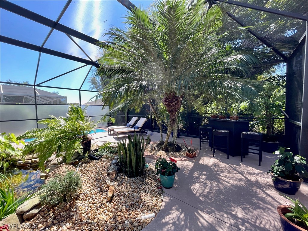 10816 Marble Brook Boulevard Lehigh Acres, FL 33936 - Photo 28 of 41 a view of a chairs and table in a backyard