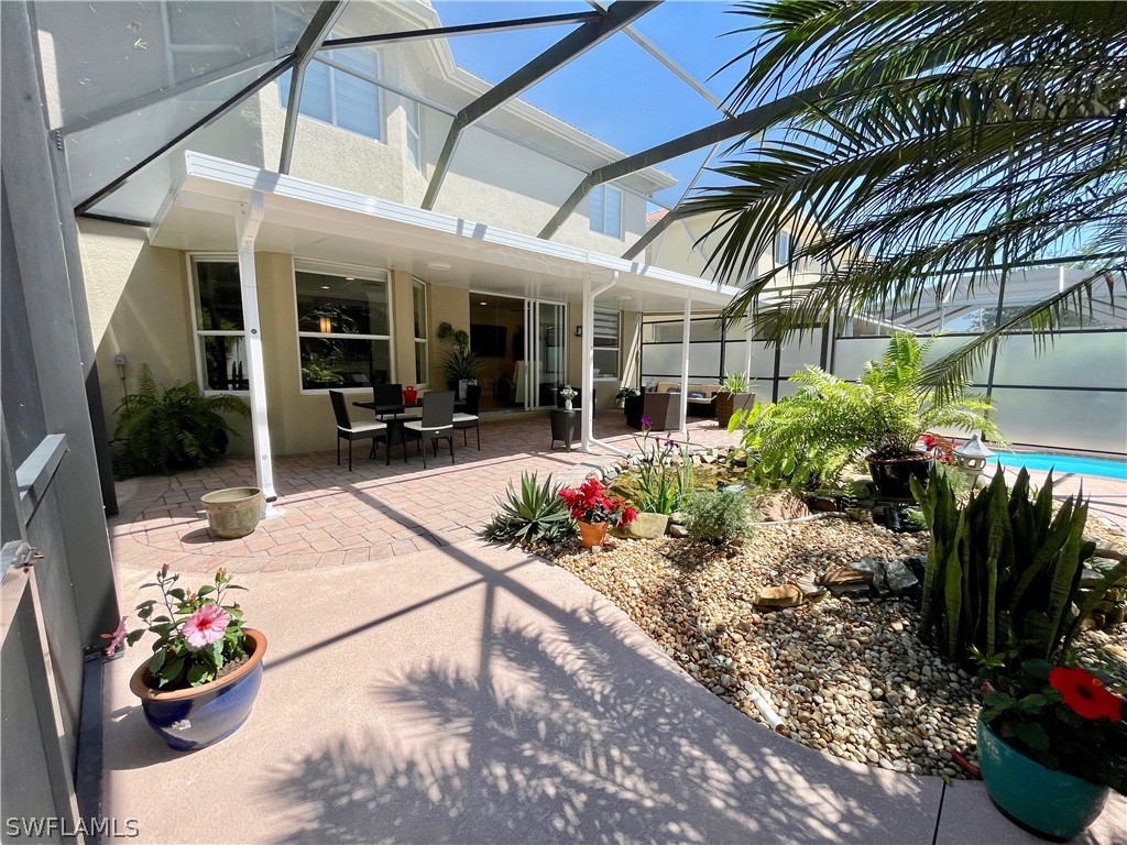 10816 Marble Brook Boulevard Lehigh Acres, FL 33936 - Photo 29 of 41 a view of a patio with table and chairs potted plants
