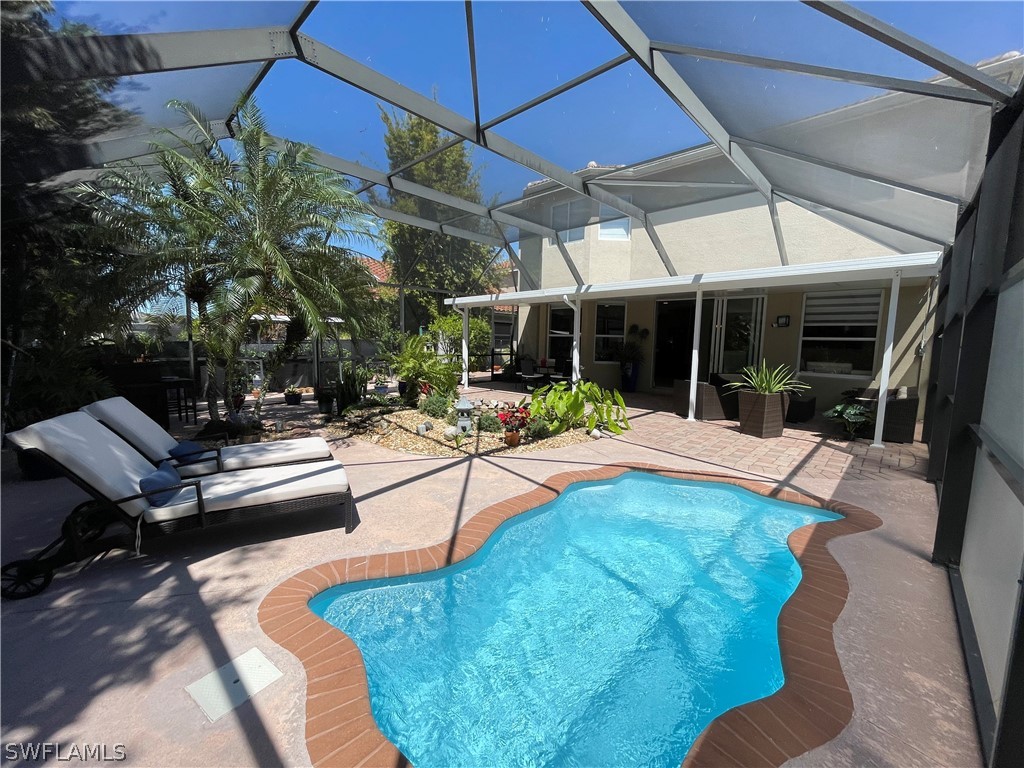 10816 Marble Brook Boulevard Lehigh Acres, FL 33936 - Photo 30 of 41 a view of a patio with a table and chairs under an umbrella