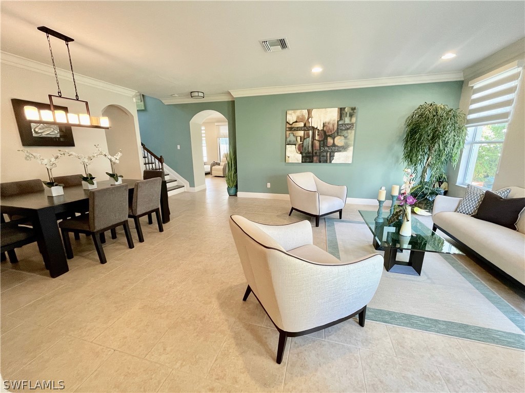 10816 Marble Brook Boulevard Lehigh Acres, FL 33936 - Photo 3 of 41 a living room with furniture and a flat screen tv
