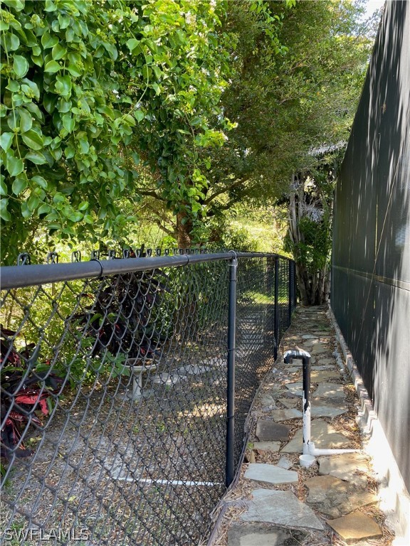 10816 Marble Brook Boulevard Lehigh Acres, FL 33936 - Photo 35 of 41 a view of a pathway with a tree