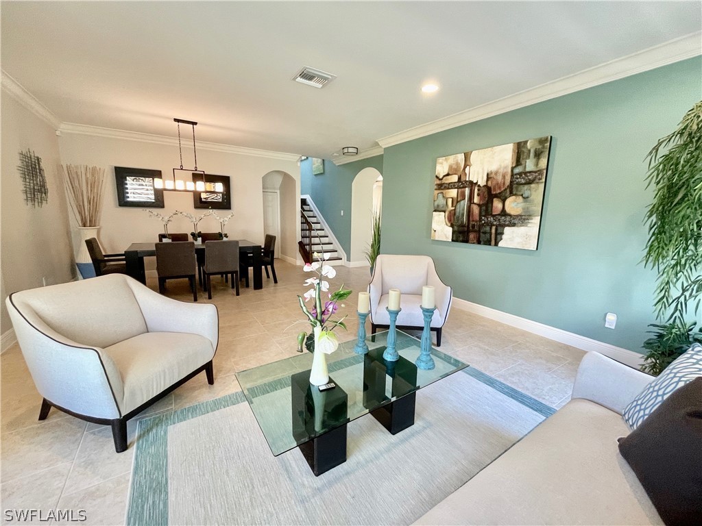 10816 Marble Brook Boulevard Lehigh Acres, FL 33936 - Photo 4 of 41 a living room with furniture and flowers