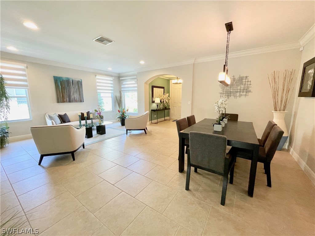 10816 Marble Brook Boulevard Lehigh Acres, FL 33936 - Photo 5 of 41 a living room with furniture a window and a chandelier