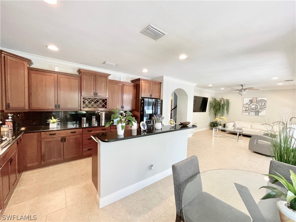 10816 Marble Brook Boulevard Lehigh Acres, FL 33936 - Photo 6 of 41 a kitchen with stainless steel appliances kitchen island granite countertop a refrigerator a stove a sink dishwasher and white cabinets with wooden floor