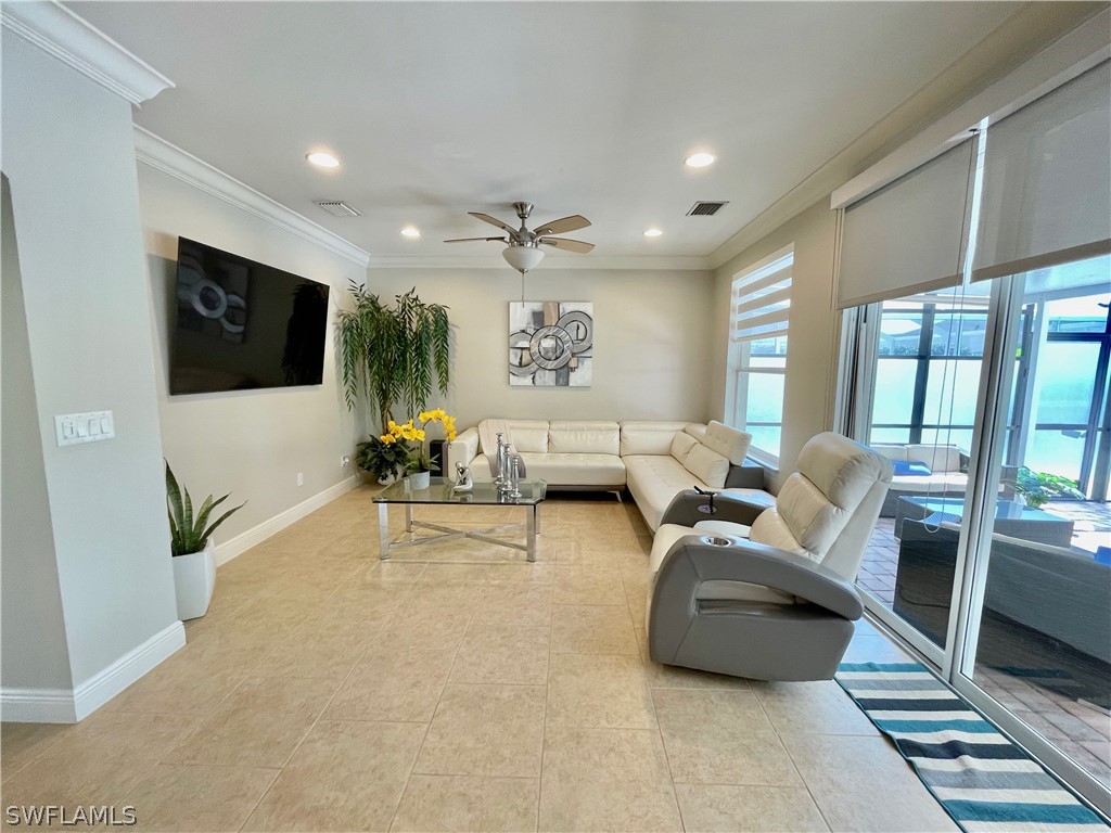 10816 Marble Brook Boulevard Lehigh Acres, FL 33936 - Photo 10 of 41 a living room with furniture and a flat screen tv