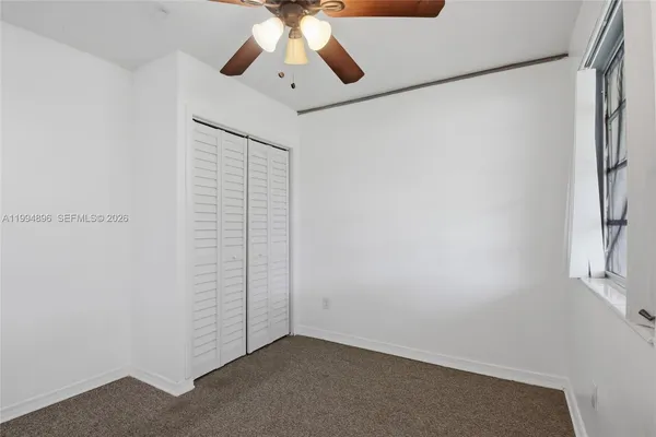 an empty room with a chandelier fan