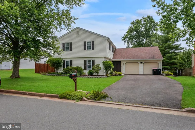a front view of a house with a garden and trees