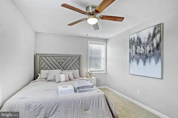 a bedroom with a large bed and a chandelier