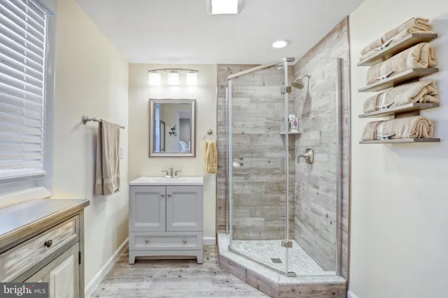 a bathroom with a bathtub shower sink and mirror