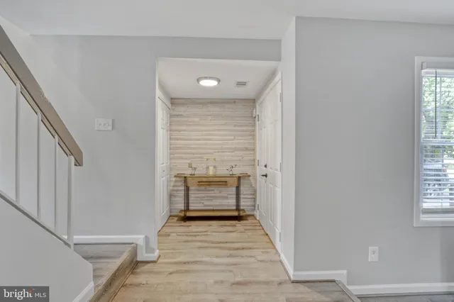 a view of a hallway with wooden floor and staircase