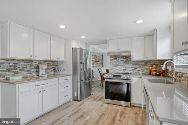 a kitchen with stainless steel appliances granite countertop a stove a sink and a refrigerator