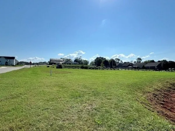 a view of a green field with sitting area