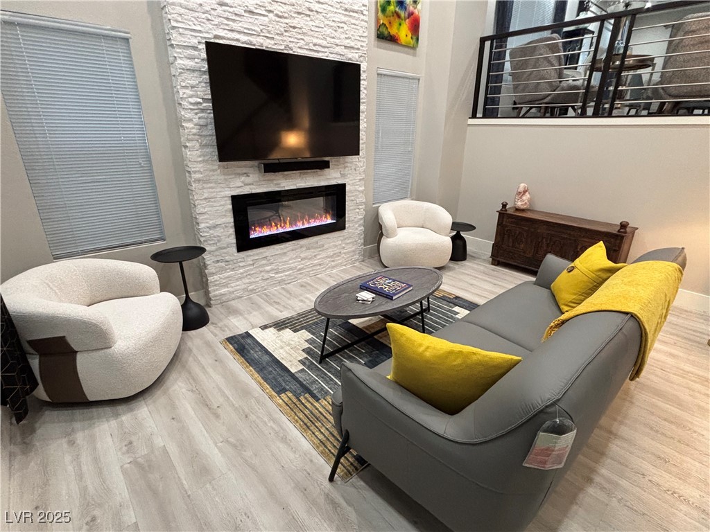 2784 Fountain Ridge Lane Henderson, NV 89074 - Photo 13 of 37 Living room featuring light wood finished floors and a stone fireplace