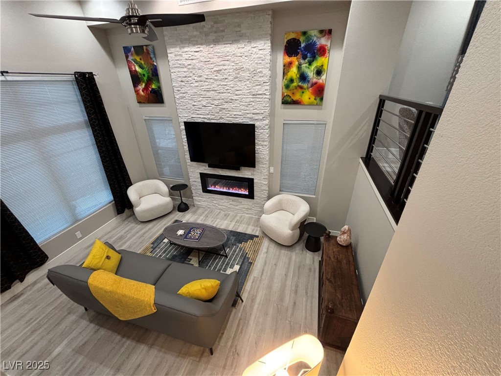 2784 Fountain Ridge Lane Henderson, NV 89074 - Photo 17 of 37 Living area with wood finished floors, a large fireplace, and ceiling fan