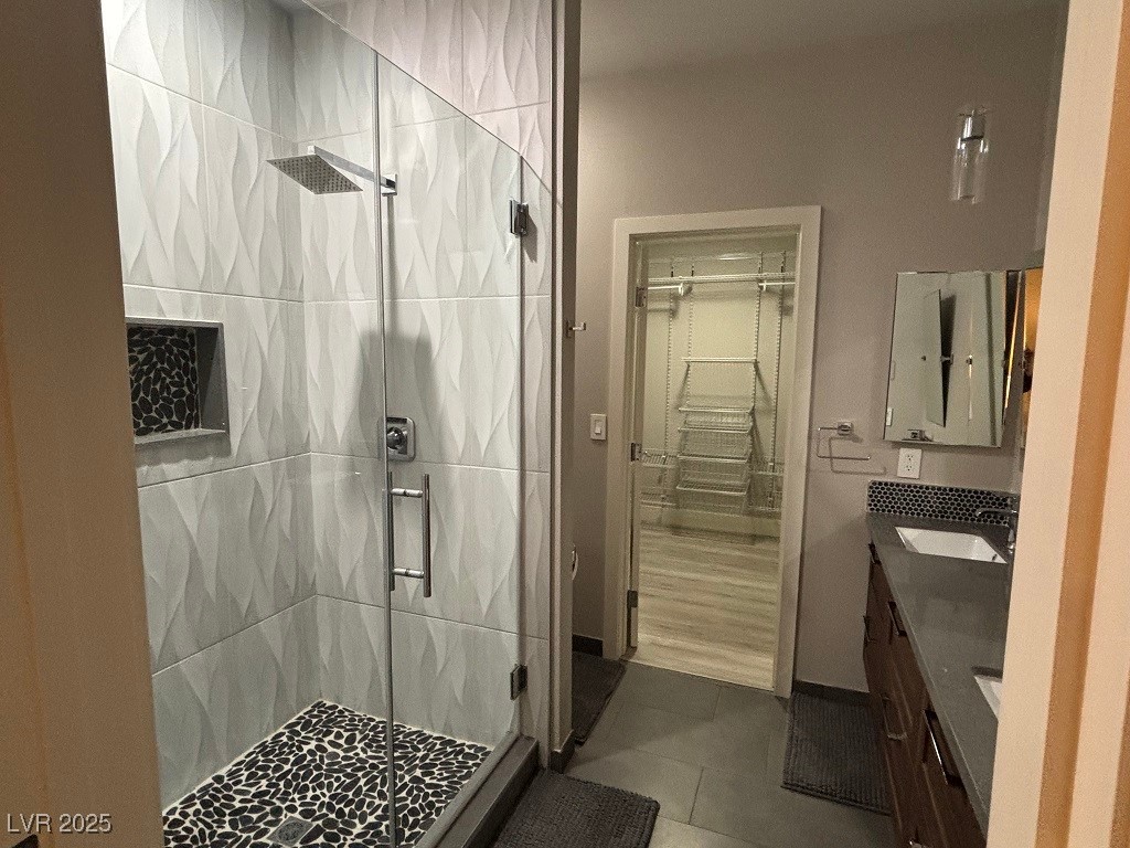 2784 Fountain Ridge Lane Henderson, NV 89074 - Photo 21 of 37 Bathroom featuring a shower stall, a walk in closet, vanity, and dark tile patterned flooring