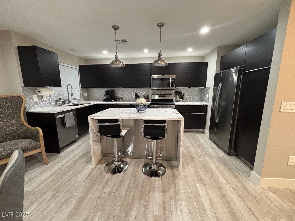 2784 Fountain Ridge Lane Henderson, NV 89074 - Photo 5 of 37 Kitchen with dark cabinets, decorative light fixtures, light stone counters, and recessed lighting