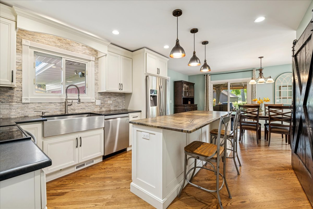 305 Pearl Street Cary, IL 60013 - Photo 3 of 25 a kitchen with stainless steel appliances kitchen island granite countertop a table chairs sink and cabinets